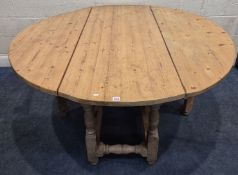 A LARGE PINE GATE LEG TABLE, raised on block and turned legs, united by stretchers, open width 151cm