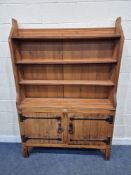 A PINE ECCLESIASTICAL WALL UNIT, with three shelves, atop a base with double cupboard doors, width