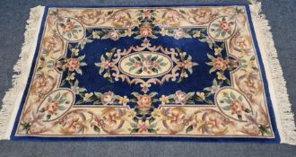 A BLUE GROUND RECTANGULAR CHINESE WOOLLEN RUG, 194cm x 124cm, condition report: in need of a