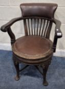 AN EARLY 20TH CENTURY OAK SWIVEL DESK CHAIR, with leatherette upholstery, scrolled open armrests,