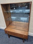 TURNIDGE OF LONDON, A MID-CENTURY TEAK DISPLAY CABINET, the double glass sliding doors enclosing a