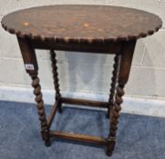 AN EARLY 20TH CENTURY OAK TABLE, with a wavy edge, raised on barley twist supports, united by