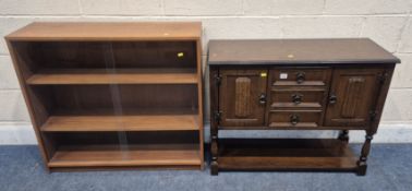 IN THE MANNER OF OLD CHARM, AN OAK DOUBLE DOOR CABINET, with three drawers, raised on block and