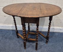 AN EARLY 20TH CENTURY OAK GATE LEG TABLE, raised on barley twist supports, united by stretchers,