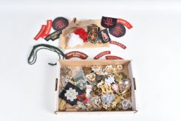 A TIN CONTAINING MILITARY CAP BADGES, FORMATION AND SHOULDER TITLES, this lot includes 4th