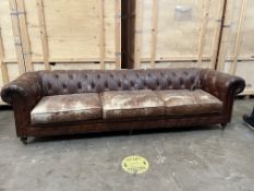 A 9.5FT LONG BROWN LEATHER CHESTERFIELD SOFA, with triple cushions, on turned feet and casters,
