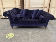 A PURPLE PLUSH VELVET CHESTERFIELD SOFA, with arm raised higher, on turned legs and brass casters,