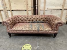 A VICTORIAN WALNUT FRAMED CHESTERFIELD SOFA, on cylindrical supports and brass casters, width 209cm,