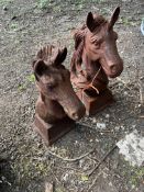 TWO CAST IRON GATE POST FINIALS IN THE FORM OF HORSES HEADS, the tallest being 47cm high.