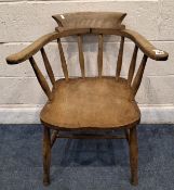AN EARLY 20TH CENTURY ELM BOW TOP CAPTAINS / SMOKERS CHAIR, with outswept armrests, raised on turned