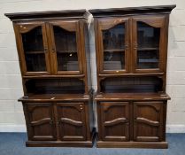 A PAIR OF MODERN MAHOGANY WALL UNITS, each with double glass doors, atop a base with double cupboard