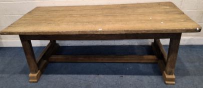 A LARGE RECTANGULAR OAK PLANK TOP TABLE, raised on block legs, later feet, united by stretchers,