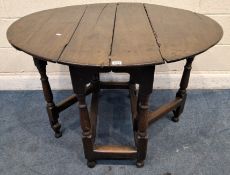 A GEORGIAN OAK GATE LEG TABLE, raised on block and turned legs, united by stretchers, open width