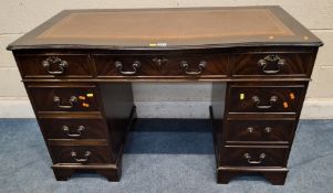A REPRODUCTION MAHOGANY TWIN PEDESTAL DESK, the serpentine top with a tanned leather writing