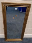 A GILT WOOD RECTANGULAR WALL MIRROR, 104cm x 52cm, alterations, losses, other wear and usage