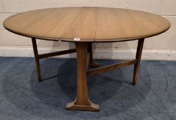 AN ERCOL ELM AND BEECH SUTHERLAND STYLE GATE LEG TABLE, raised on trestle style legs, united by