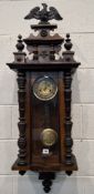 AN EARLY 20TH CENTURY MAHOGANY CASED WALL CLOCK, with an Eagle pediment, flanked by twin finials,