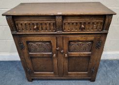 A GOOD QUALITY REPRODUCTION OAK DOUBLE DOOR CABINET, with two drawers, acanthus leaf carvings, width
