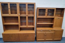A MID-CENTURY TEAK WALL UNIT, fitted with two pairs of glass doors, enclosing an arrangement of