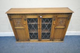 A LATE 20TH CENTURY OAK BOOKCASE, fitted with two cupboard doors, flanking double lead glazed doors,