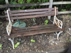 A GARDEN BENCH WITH CAST IRON ENDS, and distressed slat to seat and back, 122cm wide