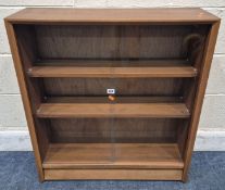 GIBBS FURNITURE, A MID CENTURY TEAK BOOKCASE, the double glass sliding doors enclosing two glass