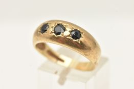 A 9CT GOLD SAPPHIRE THREE STONE RING, set with three slightly graduating sapphires, to the plain