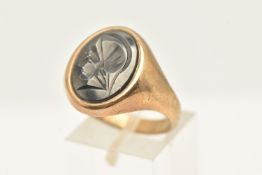 A 9CT GOLD HEMATITE RING, the oval shaped hematite carved to depict a Roman soldier, to the plain
