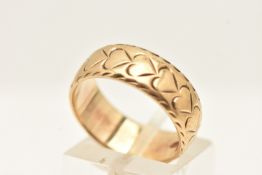A 9CT YELLOW GOLD BAND RING, etched with a repetitive heart pattern, approximate width 7mm,