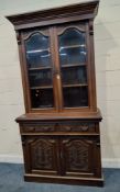 AN EARLY 20TH CENTURY MAHOGANY BOOKCASE, the double bevelled glass doors enclosing three shelves,