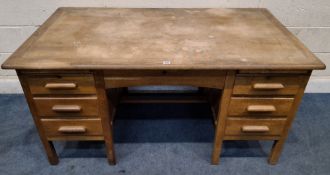 AN EARLY 20TH CENTURY OAK KNEE HOLE DESK, fitted with six assorted drawers and two brushing