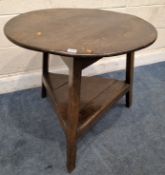 A GEORGIAN OAK CRICKET TABLE, with a circular top, raised on three splayed legs, united by a