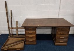 AN EARLY 20TH CENTURY OAK DESK, fitted with eight assorted drawers, raised on castors, width 153cm x