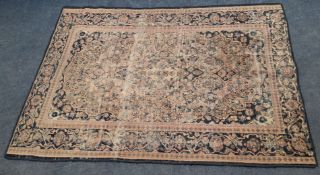 A RECTANGULAR WOOLLEN RUG, with repeating foliate patterns, surrounded by a multi-strap border,