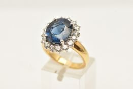 A YELLOW METAL SAPPHIRE AND DIAMOND DRESS RING, of an oval form, set with a central oval cut blue
