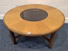 G PLAN, A MID-CENTURY TEAK CIRCULAR COFFEE TABLE, with a smoked glass insert, raised on four legs,