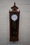 A FRANZ HERMLE WALL CLOCK, with three finials, the single glazed door enclosing an 8 inch dial,