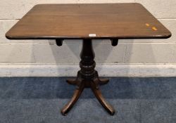 A MAHOGANY RECTANGULAR TILT TOP TABLE, raised on a turned pedestal with four legs, on brass castors,
