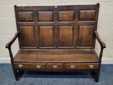 A GEORGIAN OAK SETTLE, with a panelled backrest, open armrests with turned supports, raised on