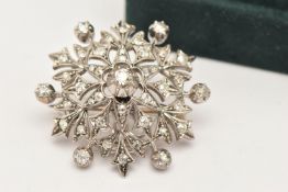 AN EARLY 20TH CENTURY DIAMOND SET COMBINATION BROOCH/PENDANT, in the form of a snowflake, set with