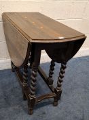 AN EARLY 20TH CENTURY OAK OVAL GATE LEG TABLE, raised on barley twist legs, united by stretchers