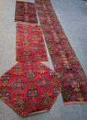 A LARGE RECTANGULAR WOOLLEN CARPET RUNNER, with repeating geometric patterns, along with three small