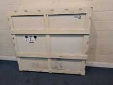 A LARGE CREAM PAINTED WOODEN SHIPPING CRATE, with a removable door, enclosing some packaging