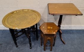 A BRASS TOP TRAY TABLE, raised on an ebonised folding frame, with Mother of Pearl inlay, a 19th