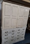 A WHITE AND CREAM PAITNED LARGE CABINET, fitted with double cupboard doors, atop a base with four