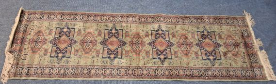 A SMALL RECTANGULAR VISCOSE CHIRAZ RUNNER, with repeating geometric patterns, surrounded by a