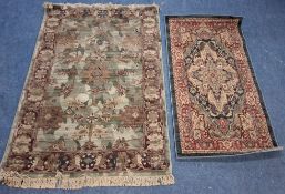 A GREEN GROUND RECTANGULAR WOOLLEN RUG, with repeating foliate patterns, surrounded by a border,