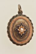 A VICTORIAN YELLOW METAL AND ENAMEL MOURNING PENDANT, of an oval form, set with a central split