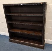 AN EARLY 20TH CENTURY OAK OPEN BOOKCASE, with geometric carved details, and three adjustable shelves