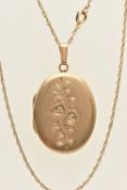 A 9CT YELLOW GOLD LOCKET WITH CHAIN, an oval form locket with floral detail, heavily rubbed